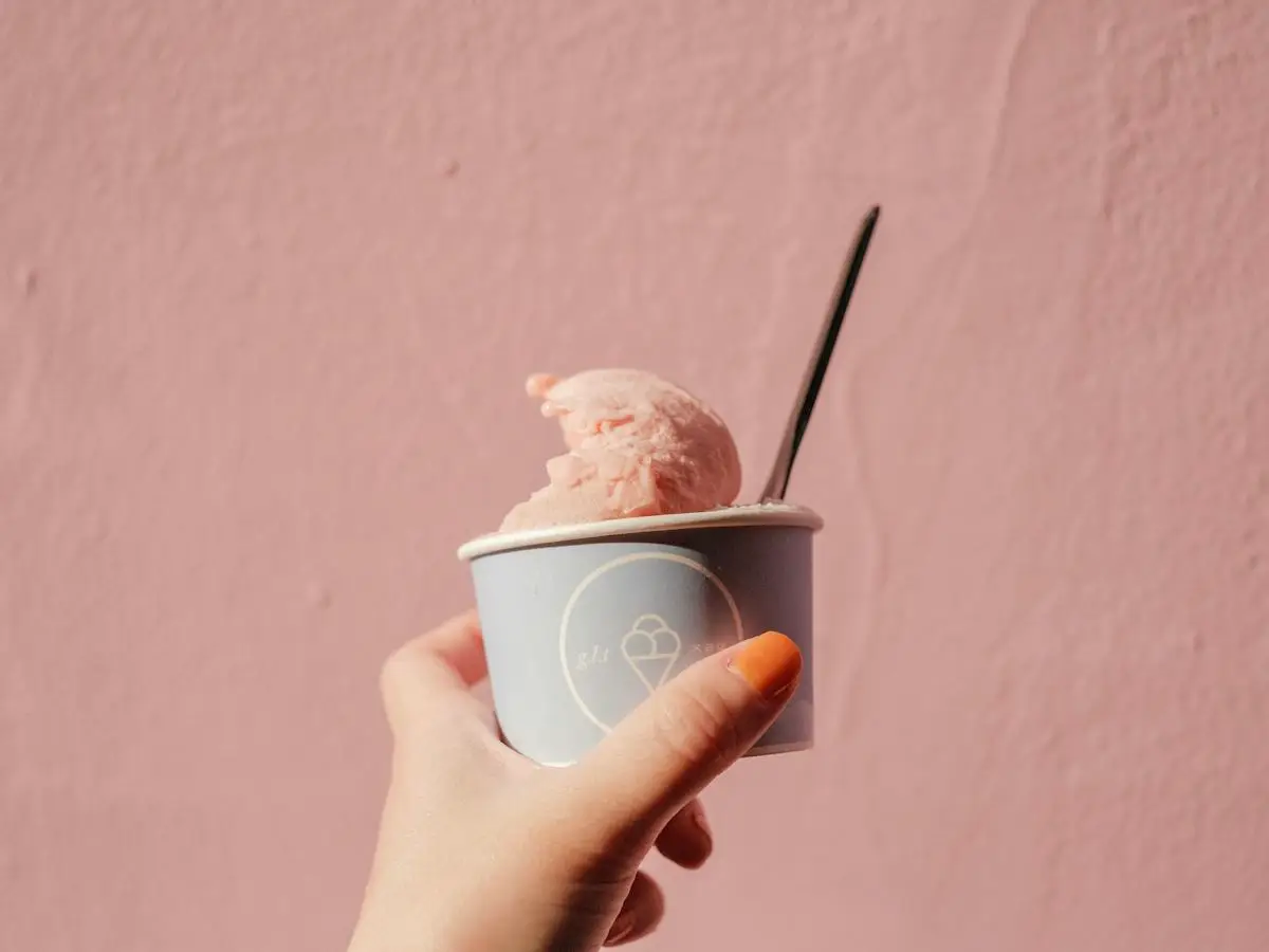 Becher mit Eis vor warmfarbiger Wand
